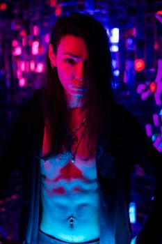 Portrait of a transgender model with a naked torso in a studio with neon lighting
