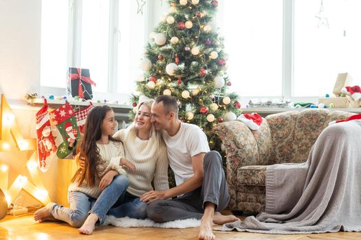 Christmas. Family. Happiness. Top view of dad, mom and daughter on the floor at home