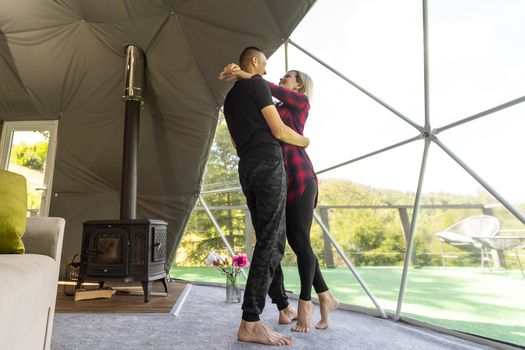 a couple in geo dome tents. Cozy, camping, glamping, holiday, vacation lifestyle concept. Outdoors cabin, scenic background