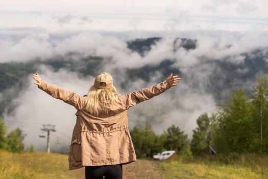 a woman rests after a hike in the mountains.