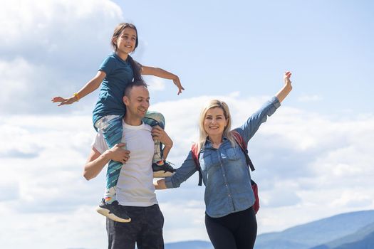Family hiking parents with child outdoor travel in mountains active vacations lifestyle mother and father backpacking together