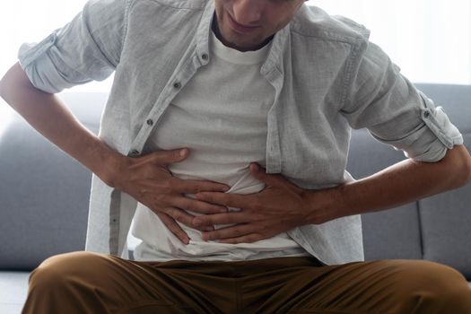 Cropped close up studio photo portrait of upset sad scared worried troubled gut having stomach ache disorder wear denim pants isolated grey background