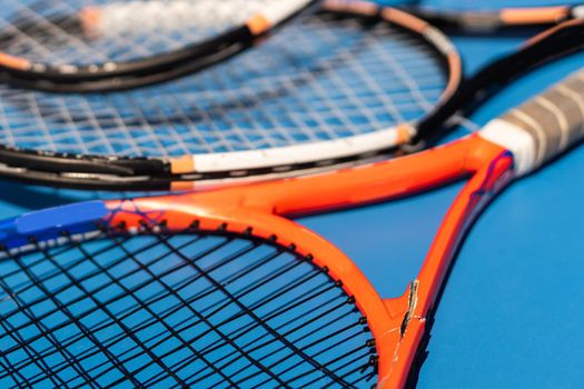 broken tennis rackets blue tennis court.