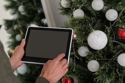 Digital tablet computer with isolated screen in male hands over cafe background.