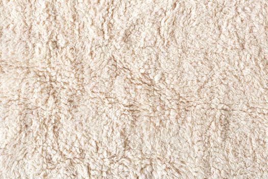 beige soft ecological fur textile background, flatlay