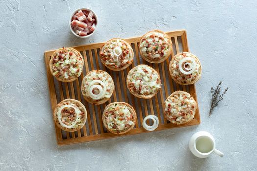 mini portions of flammekueche, or tarte flambee, french and german speciality, on the wooden cooling grid, top view