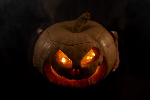 The witch is holding a pumpkin jack about a lantern glowing in the dark. Halloween