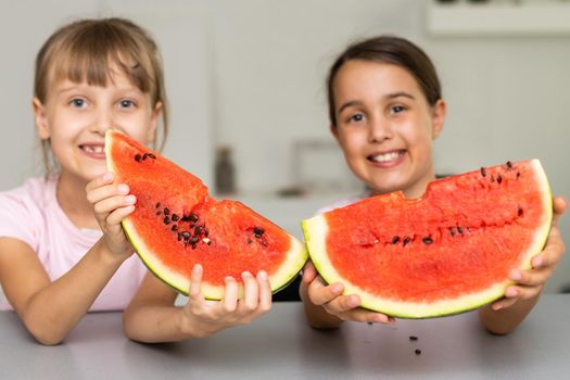 Two girls eating Watermelon isolated at home.