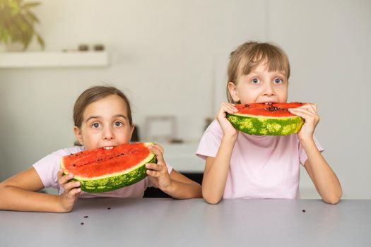 Two girls eating Watermelon isolated at home.