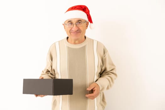 Smiling happy elderly man with a christmas present. Isolated over white background.