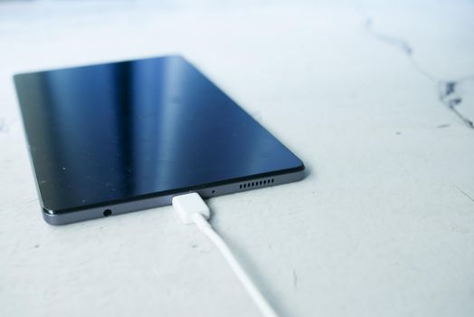 charging s digital tablet with a cable on white background ,