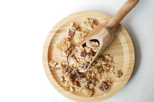 top view of granola Musli on wooden board on white .