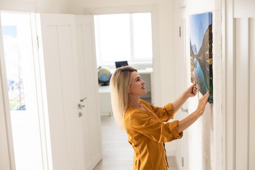 Woman hanging a photo canvas on a wall