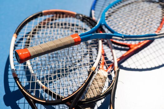 broken tennis rackets blue tennis court.