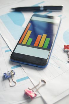 top view of financial chart display on smart phone on table .