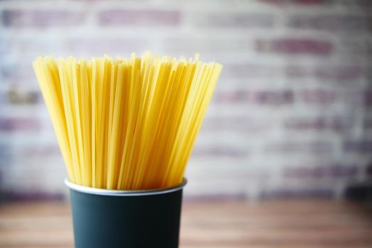 Yellow long spaghetti in a container on table ,