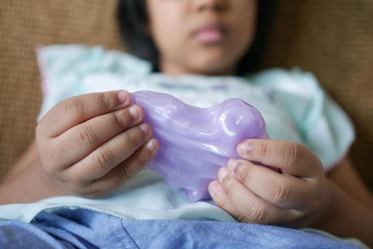 child Hand holding pink color slime .