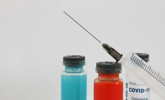 One ampoule with covid vaccine, blue and red ampoule with medicine to strengthen immunity.