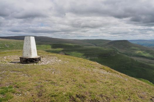 Triangulation pillar on Murton Pike looking over the Eden Valley and North Pennines, Cumbria, UK