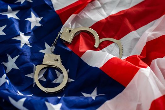 Police handcuffs on the USA flag, close-up,