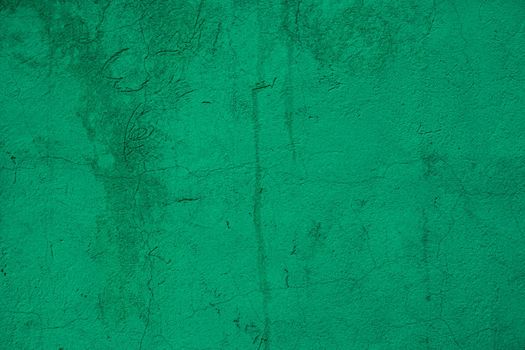 An old painted cement wall.Old scuffed green plaster on wall with sweat.