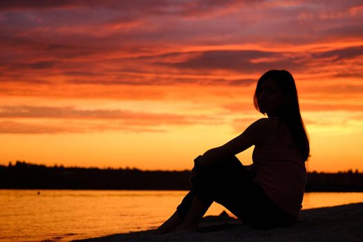 Alone woman sitting watching the sunset sunrise. download photo