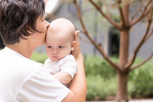 Portrait of beautiful happy smiling mother with baby outdoor.