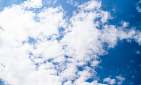 Summer sky. Cumulus clouds on a blue background. Partly cloudy. Dark clouds and white clouds.