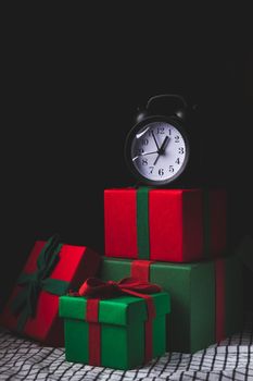 Waiting for the new year. Clock with an alarm clock and a gift. Happy New Year. Christmas presents .