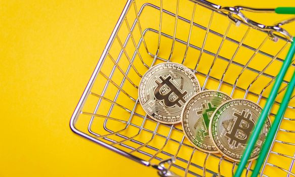 Bitcoin in a shopping cart. Buying and paying with cryptocurrencies. Currency exchange.