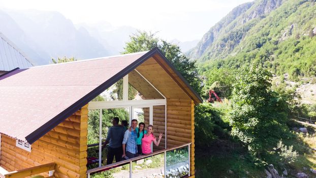 Cheerful family on terrace of mountain house together.