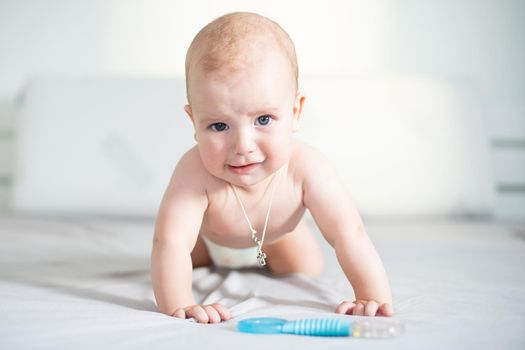 Six month boy sits on the white background.