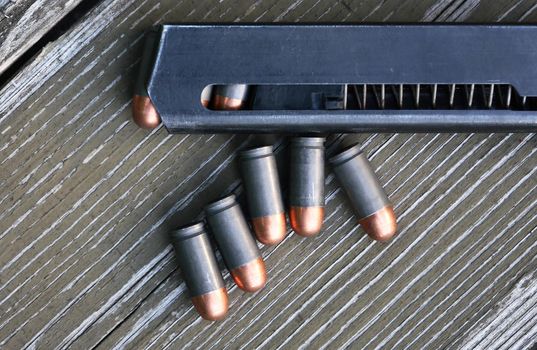 Handgun cartridges closeup on old wooden background