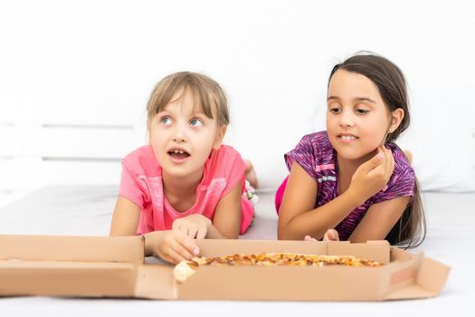 Attractive little girls posing with pizza boxes.