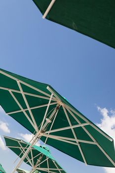 Sun blue and white open umbrella, comfortable rest by the ocean with personal beach parasol on beautiful cote dazur coastline, safe tan accessory, sunstroke protection