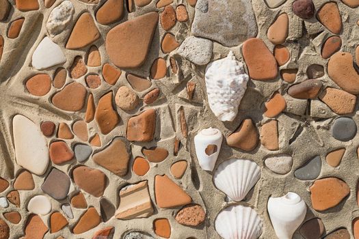 Concept of ancient culture Closeup photo of broken colored stones and sea shell with pearl mosaic background with glass and polish