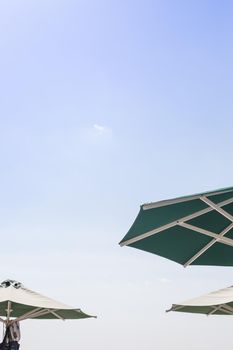 Sun blue and white open umbrella, comfortable rest by the ocean with personal beach parasol on beautiful cote dazur coastline, safe tan accessory, sunstroke protection