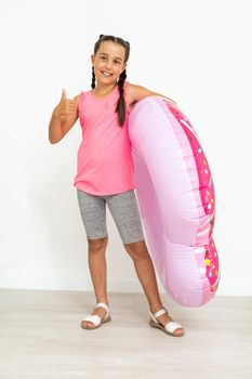 Caucasian girl with big pink rubber ring.