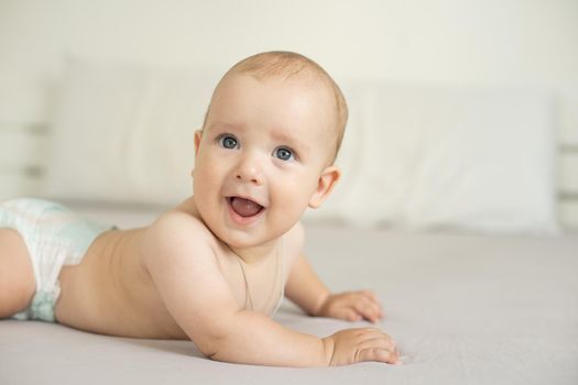 Portrait of a crawling baby on the bed in her room.