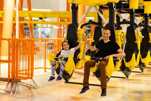 Father and daughter having fun on rollercoaster.