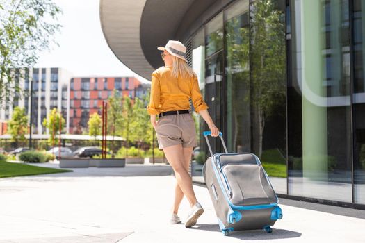 attractive woman with suitcase going on holidays.