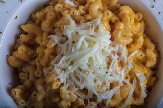 Mac and cheese, american style macaroni pasta with cheesy sauce on dark rustic table, top view. High quality photo