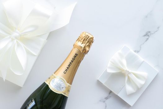 Wedding celebration, lifestyle and luxury present concept - A champagne bottle and a gift box on marble