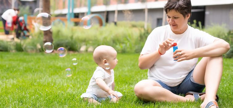 Portrait of beautiful happy smiling mother with baby outdoor.