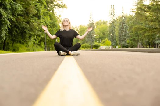 Attractive young woman walks along the line of the road enjoying nature