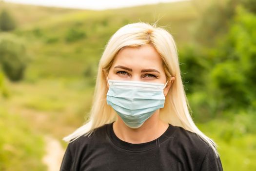 Closeup photo of young beautiful woman in reusable virus protective mask on face against coronavirus