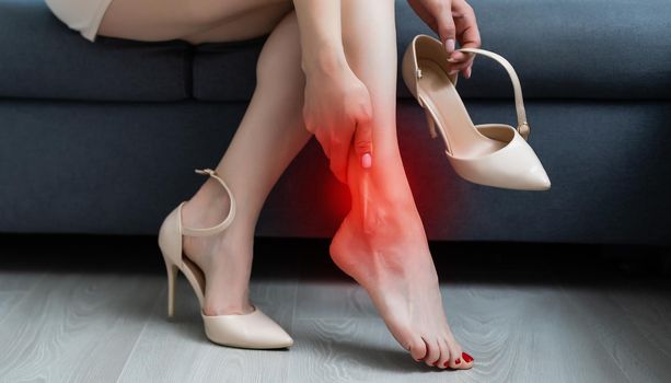 Woman in heels massaging tired legs.