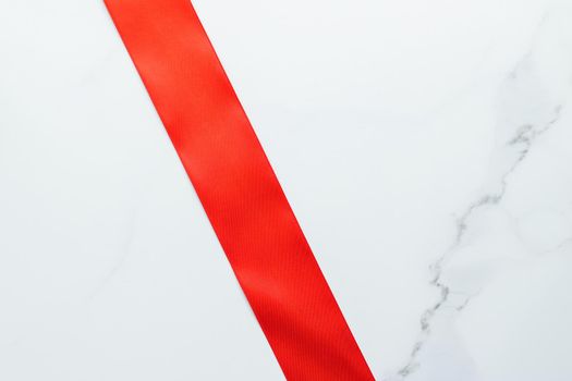 Holiday decor, feminine design and flatlay concept - Red silk ribbon on marble, top view