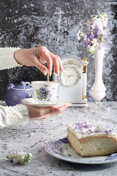 still life with black tea and cheese cake, spring bouquet of delicate lilac flowers. High quality photo