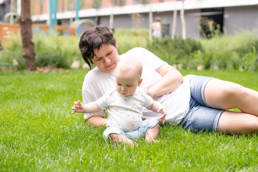 Portrait of beautiful happy smiling mother with baby outdoor.